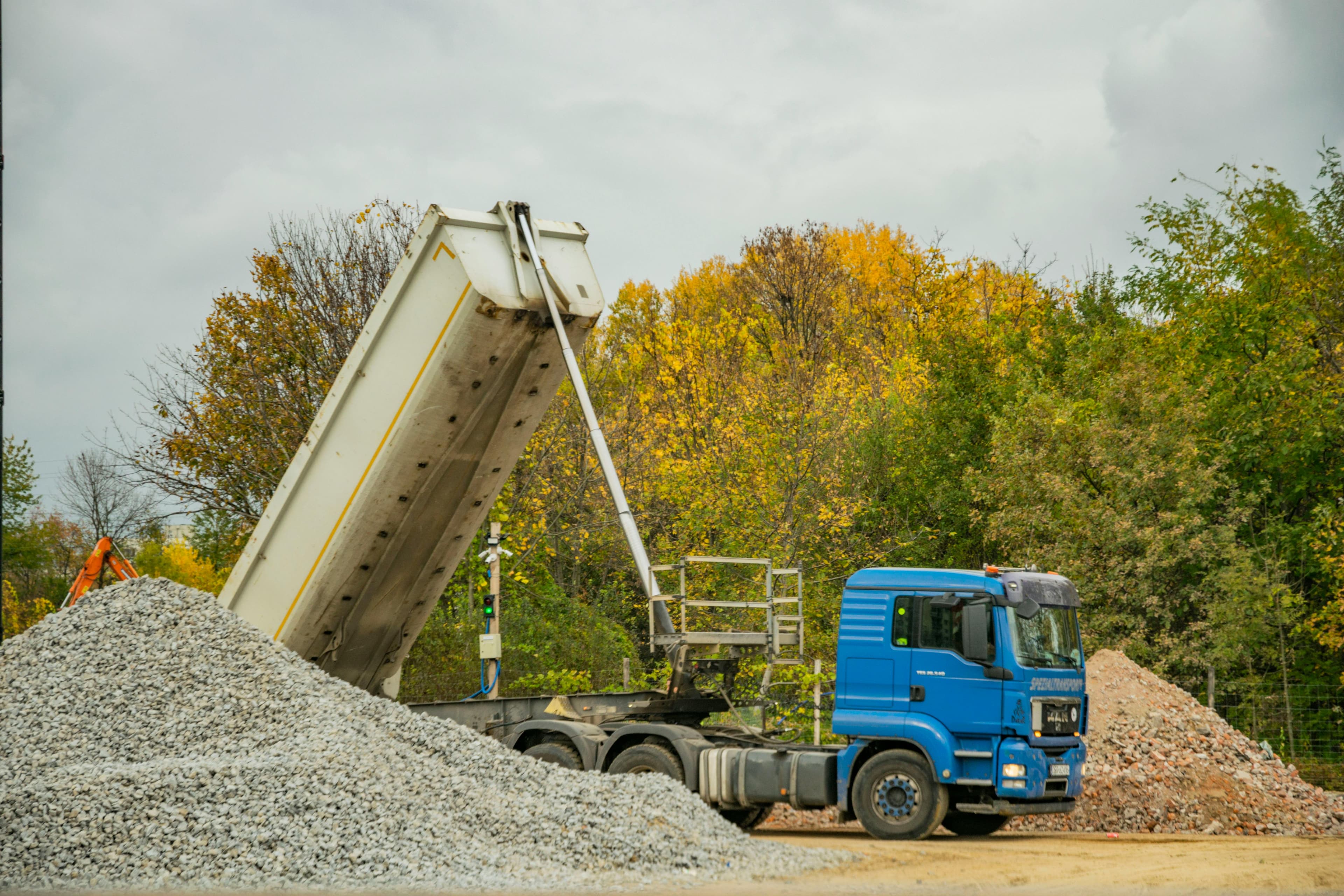 Dump truck unloading gravel at a work site