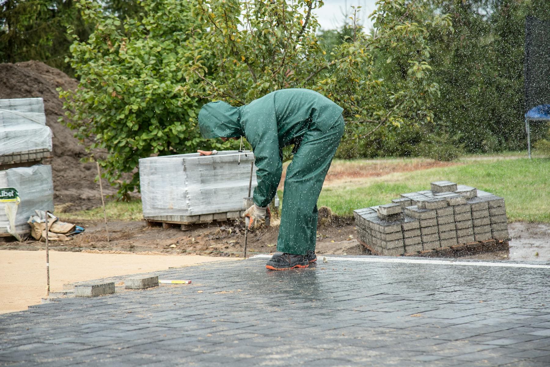 Worker installing paving stones on an outdoor path